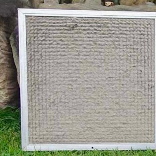 A ducted return air filter packed with a layer of grey dust before cleaning